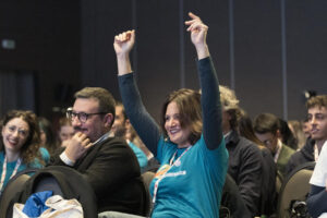 Ragazza sorridente partecipa dalla platea ai talk di #GiovanioltrelaSM - Tempo